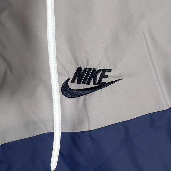 Chaqueta cortavientos Nike blanca, gris y azul 